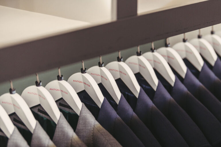 Row of suit pants on hangers in the Anton Meyer showroom