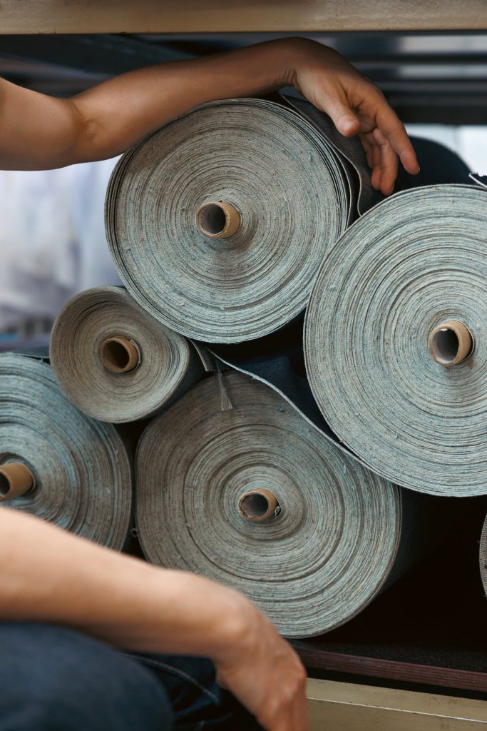 Denimstoffballen im Regal des Ateliers
