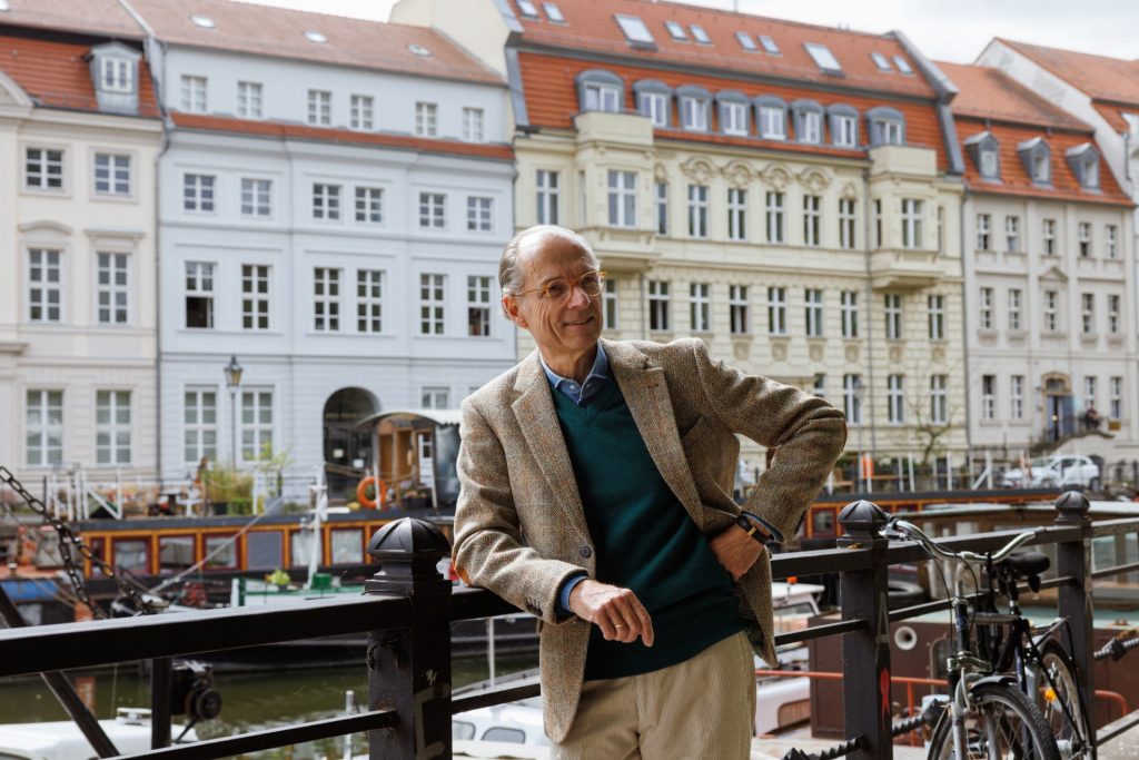 Harris-Tweed-Sakko und tannengrüner Pullover an der Spree, dahinter die Fassaden am Märkischen Ufer