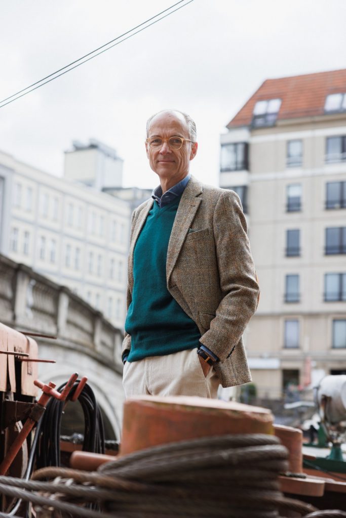 Harris-Tweed-Sakko und tannengrüner Pullover von William Lockie zwischen rostigen Pollern
