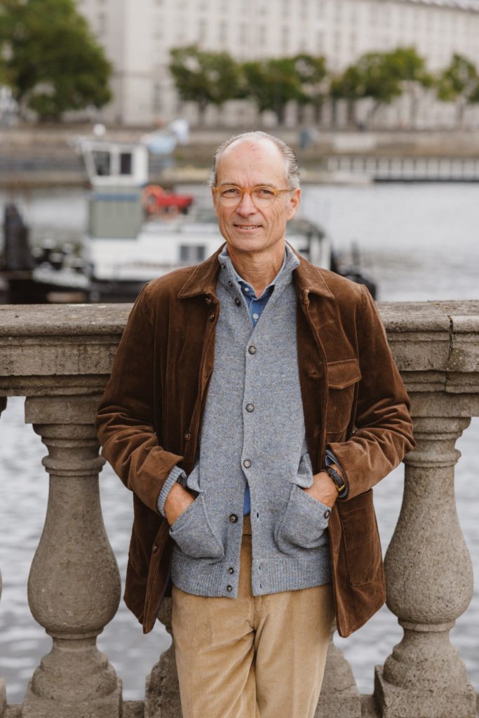 Kord-Sakkojacke von Beaver’s Fulham über dem melierten Cardigan, Ganzfigur an der Brüstung