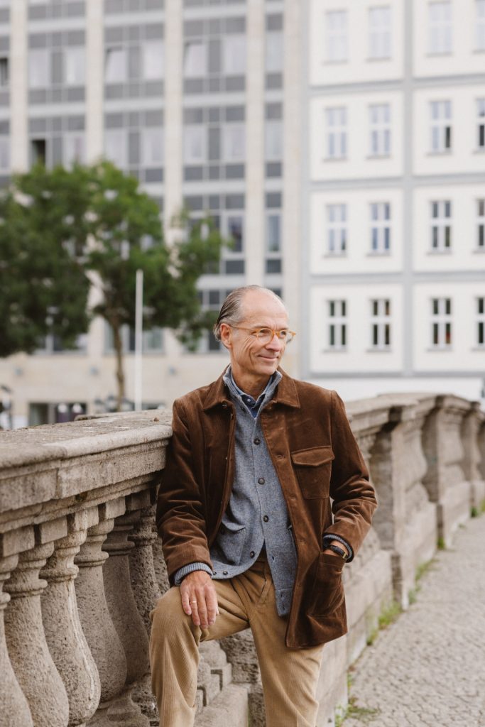 Kordjacke und Cardigan an der steinernen Balustrade, dahinter die Häuser am Ufer