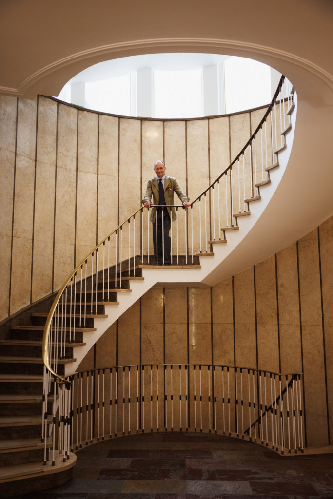 Weite Aufnahme im ovalen Treppenhaus, die Figur klein auf dem Absatz