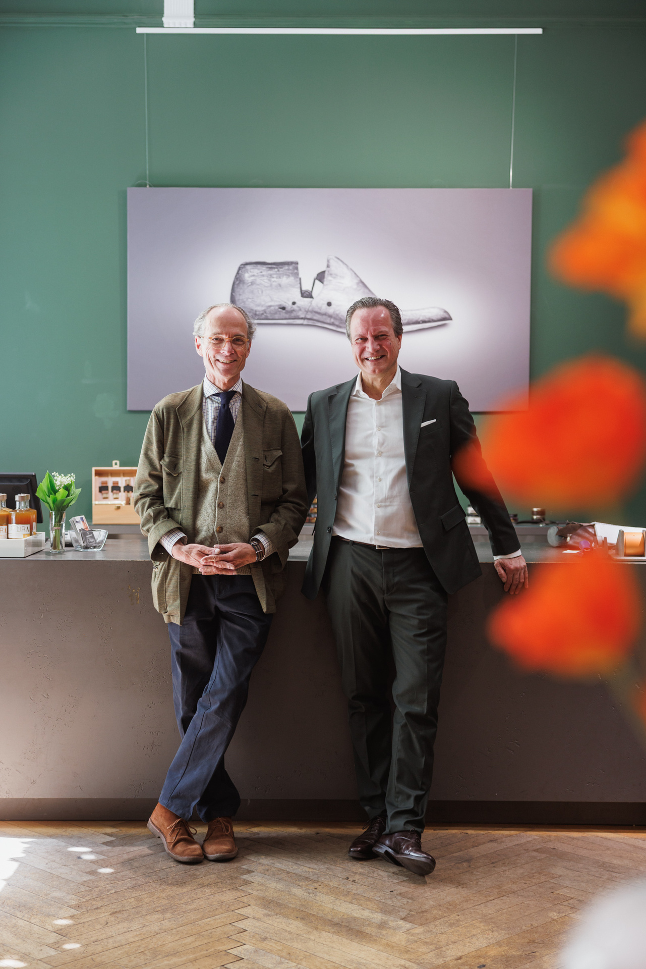 Udo Robakowski und Bernhard Roetzel vor dem großformatigen Bild eines Schuhleistens