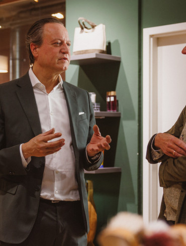 Udo Robakowski im Gespraech mit Bernhard Roetzel im Ladengeschaeft von Schuh Konzept in Berlin, im Hintergrund Regale mit Pflegemitteln und eine Ausputzmaschine