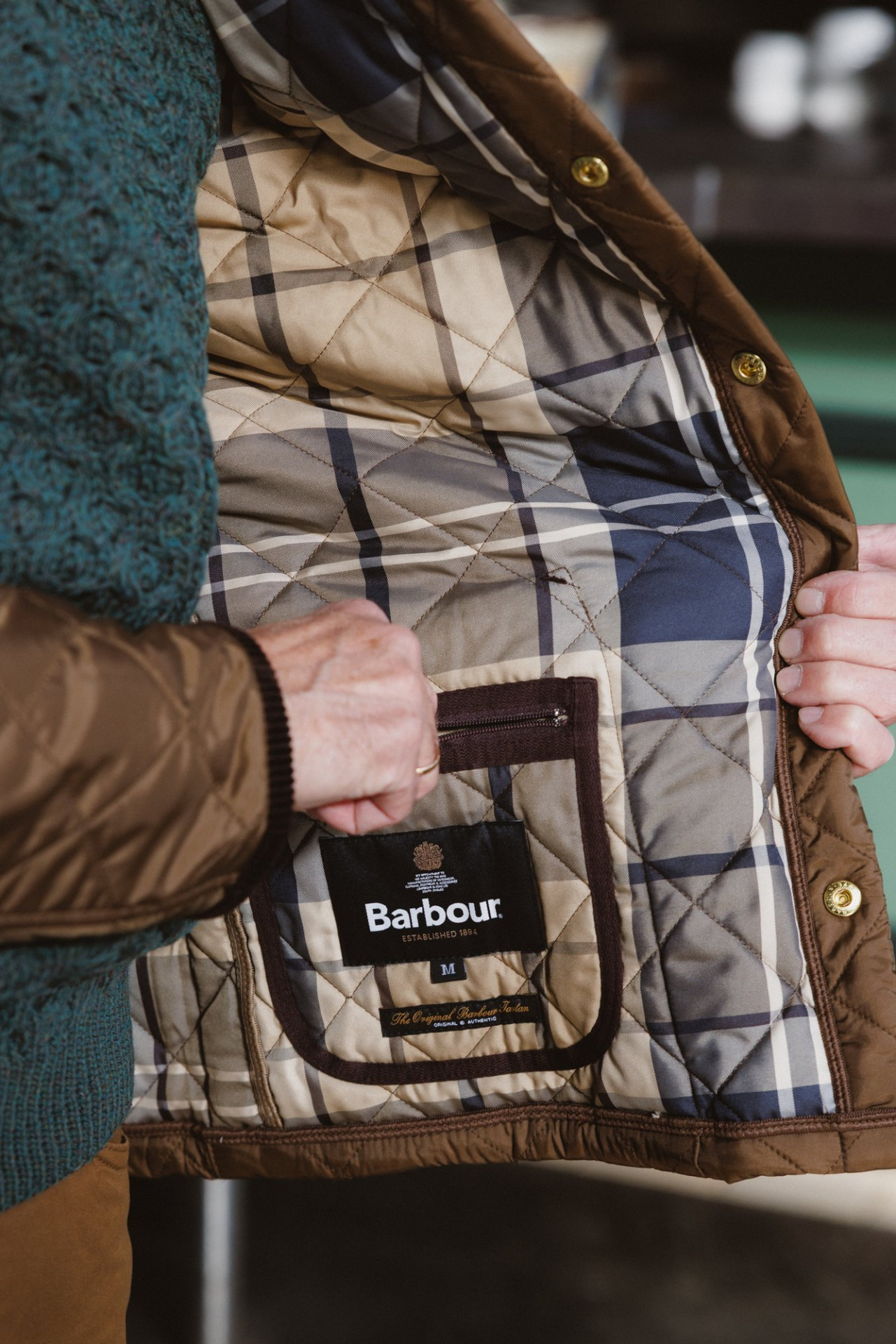 Das Karofutter der Steppjacke mit dem Barbour-Etikett an der Innentasche