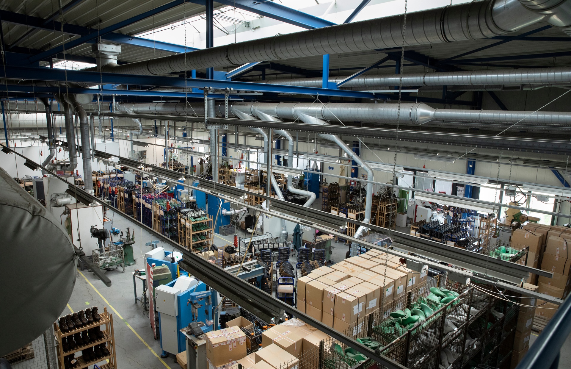 Blick von oben in die Produktionshalle von Hanwag in Vierkirchen mit Maschinen, Regalen und Kartons